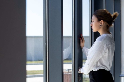 front-view-young-beautiful-lady-white-shirt-black-trousers-looking-distance-through-window-hall-waiting-daytime-building-job-activity-1.jpg